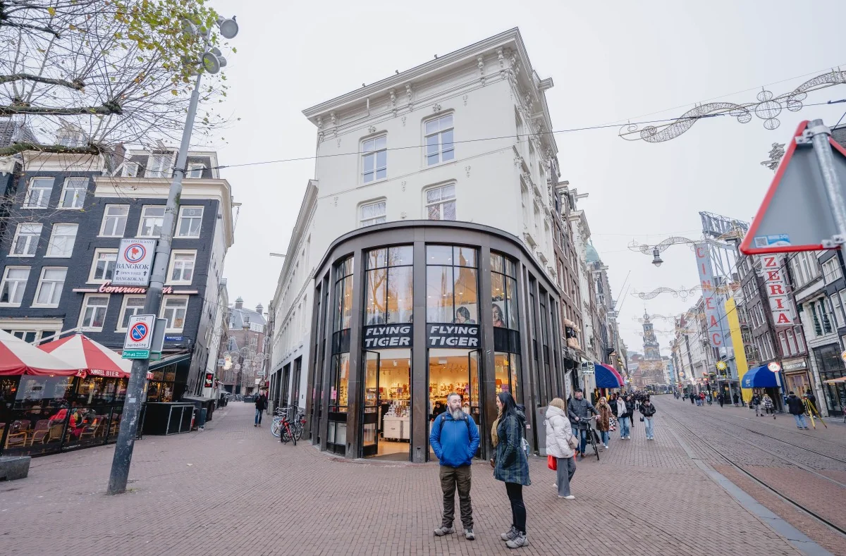 Winkelpand van Flying Tiger op de hoek van de Korte Reguliersdwarsstraat en de Kalverstraat in Amsterdam, met voorbijgangers op straat.